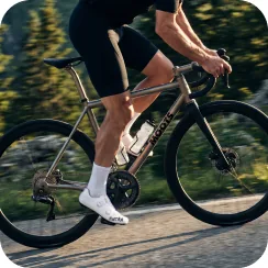 Cyclist riding on a road showcasing the precision power measurement of the pedals